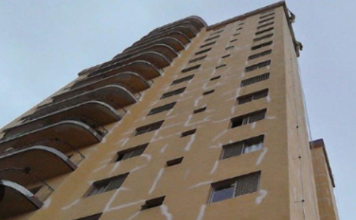 Engenheiro civil inspecionando trincas e rachaduras em parede de imóvel no litoral catarinense, em vistoria técnica de avaliação de danos.